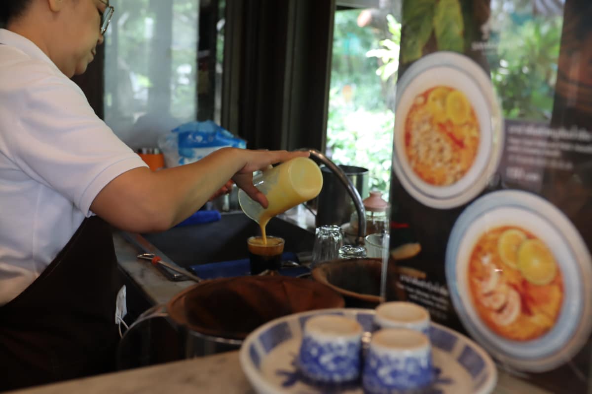 A traditional drink poured at the Samantao counter, with the vintage tin display behind