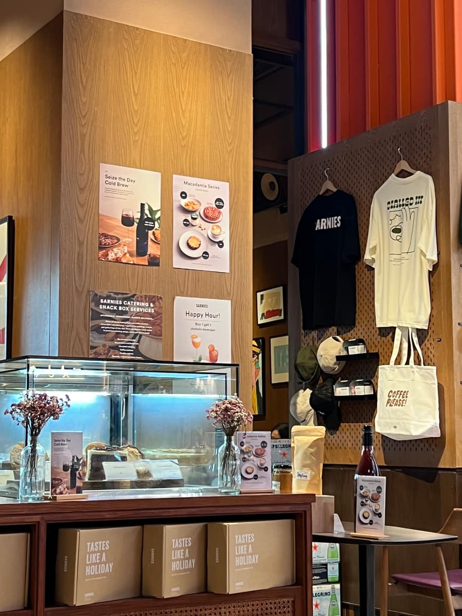 The Sarnies retail display, with branded tees, a coffee-please tote and boxes of beans