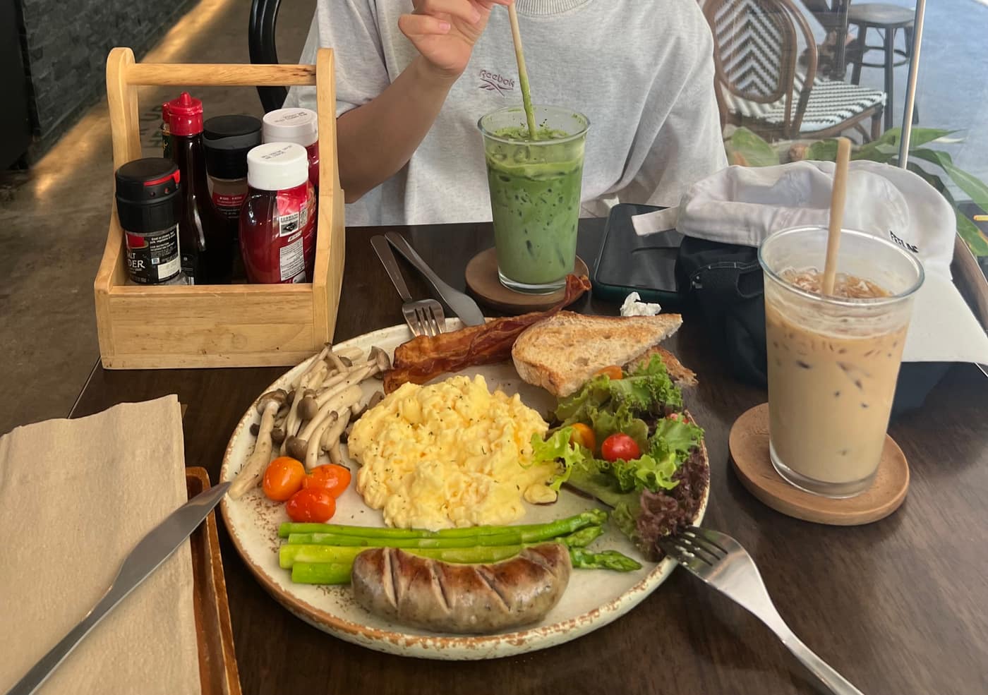 A brunch plate of scrambled eggs, sausage, mushrooms and salad with an iced matcha and iced latte at Thea Cafe