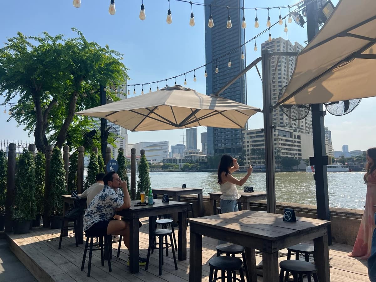 Riverside terrace tables under parasols on the Chao Phraya at Hong Sieng Kong