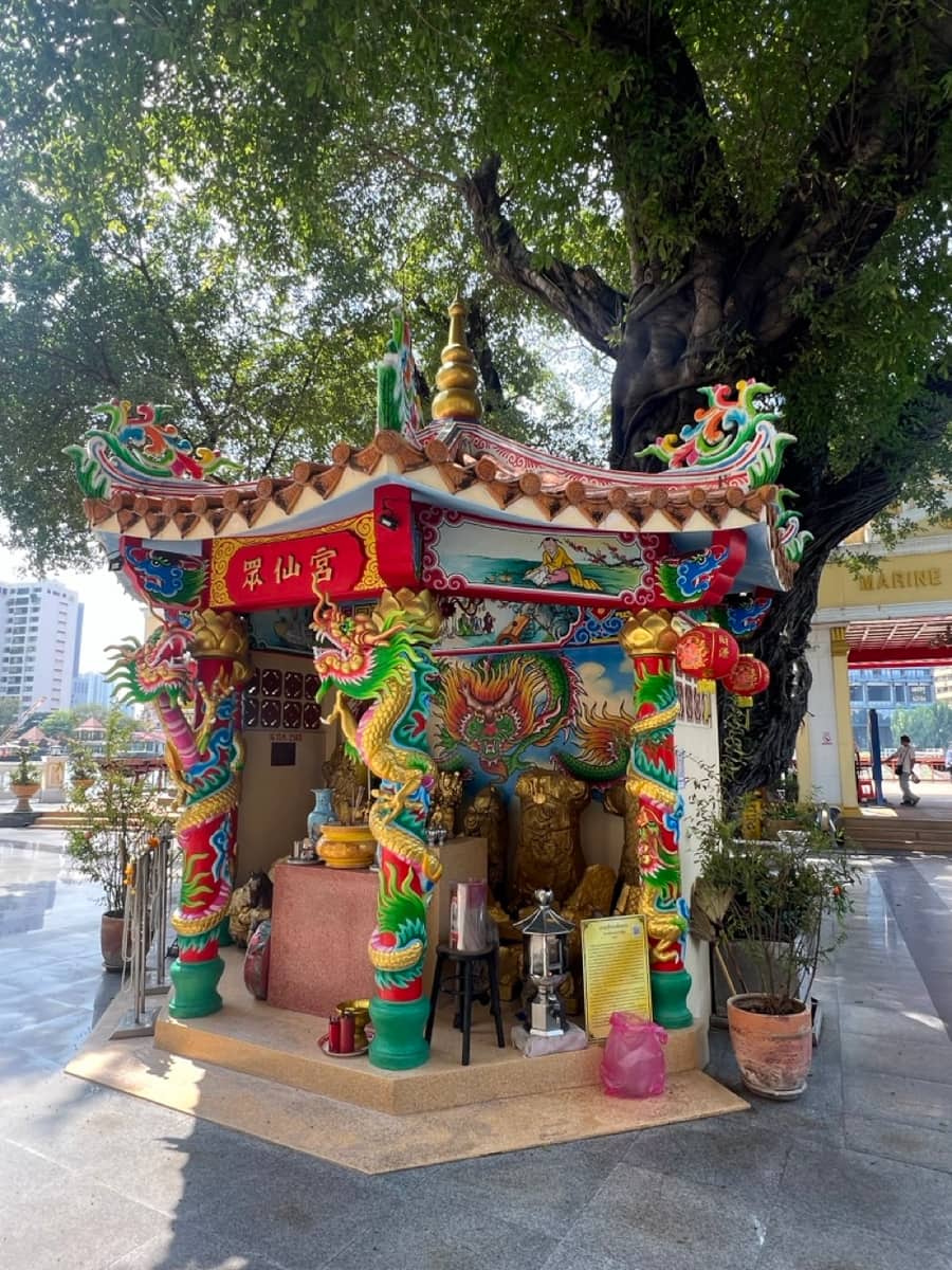 A colourful Chinese dragon shrine under a large tree at the Marine Department pier