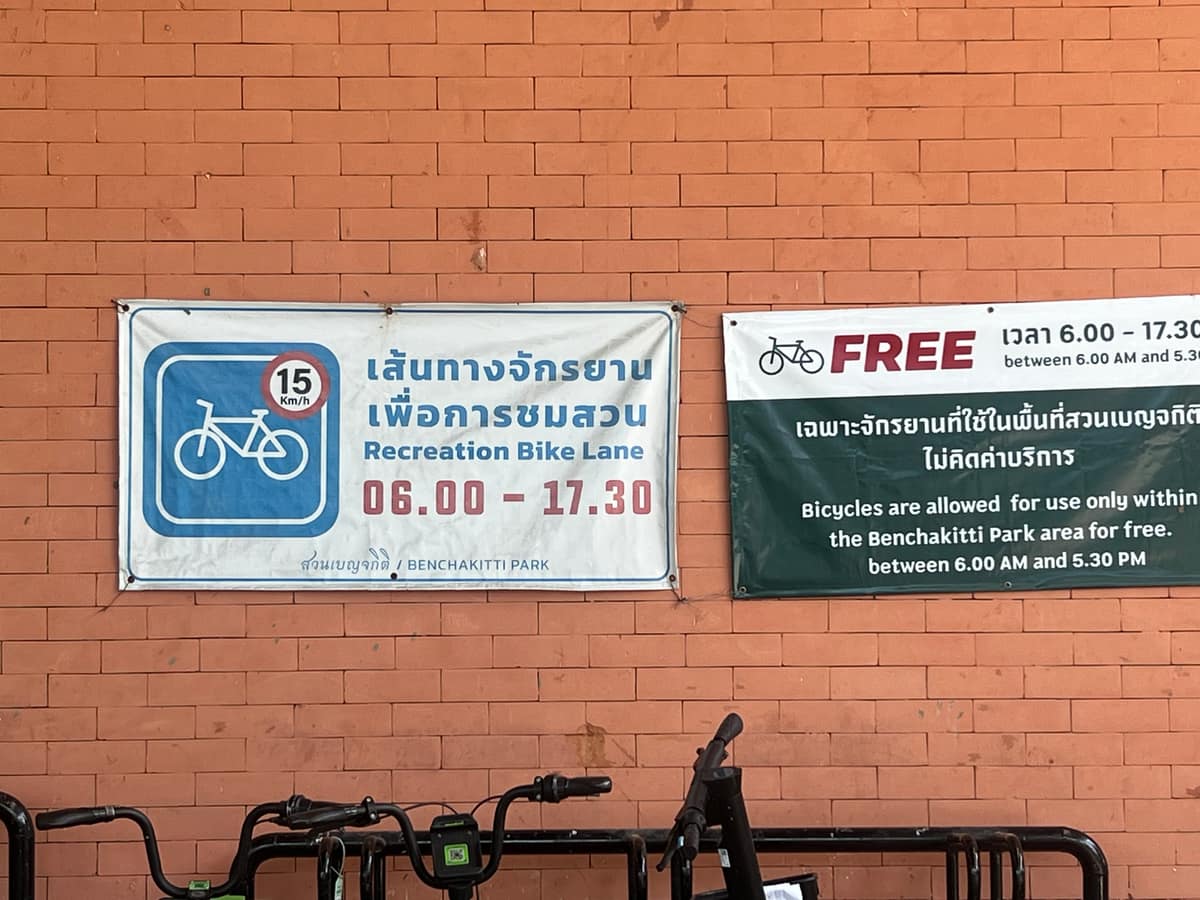 Park signboard reading Recreation Bike Lane 06.00 to 17.30 and Bicycles free within Benjakitti Park, 6am to 5.30pm