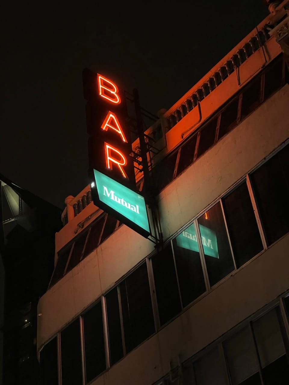 Mutual Bar sign lit up at night in Bangkok